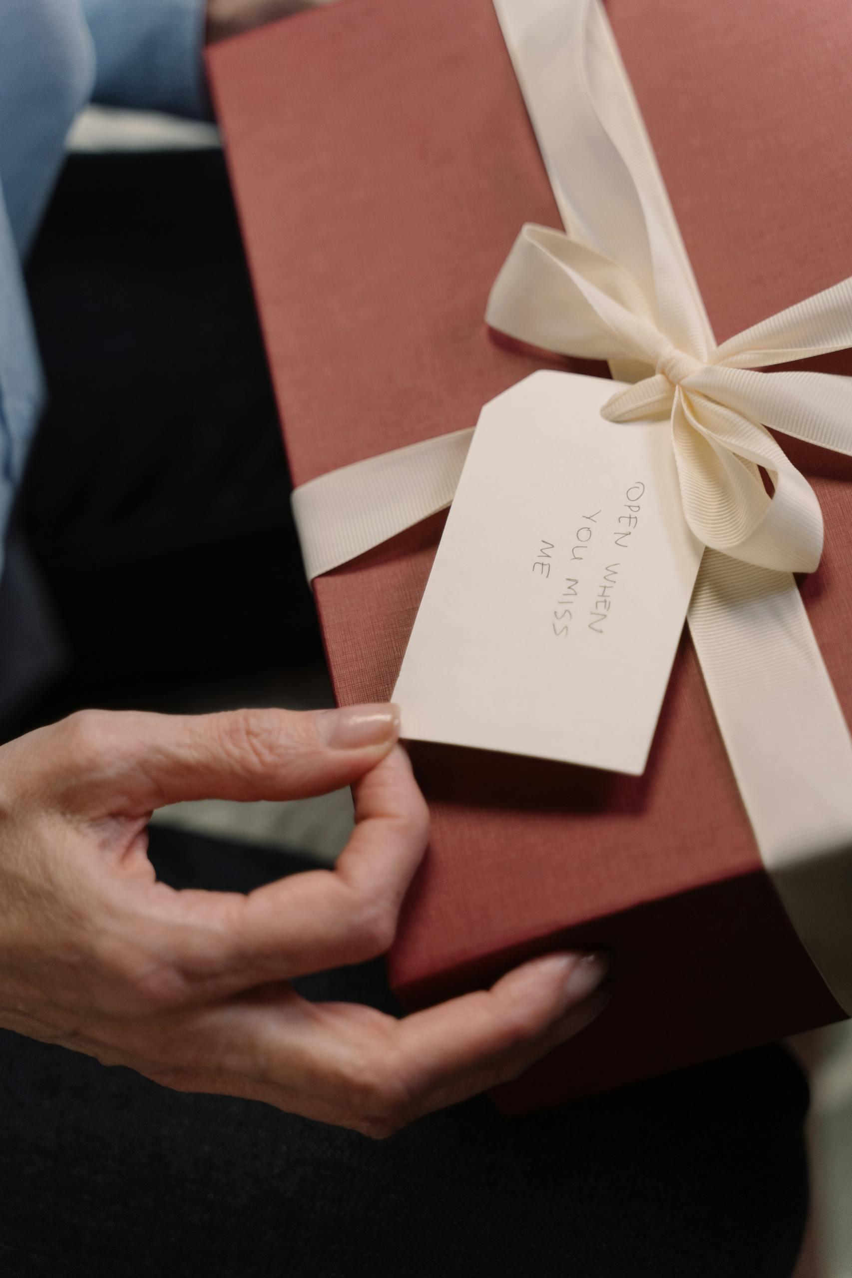 Close-up of a stylishly wrapped chic gift box for her with an attached personal note.