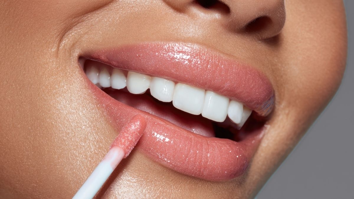 best lip oil being applied on smiling woman with beautiful white teeth