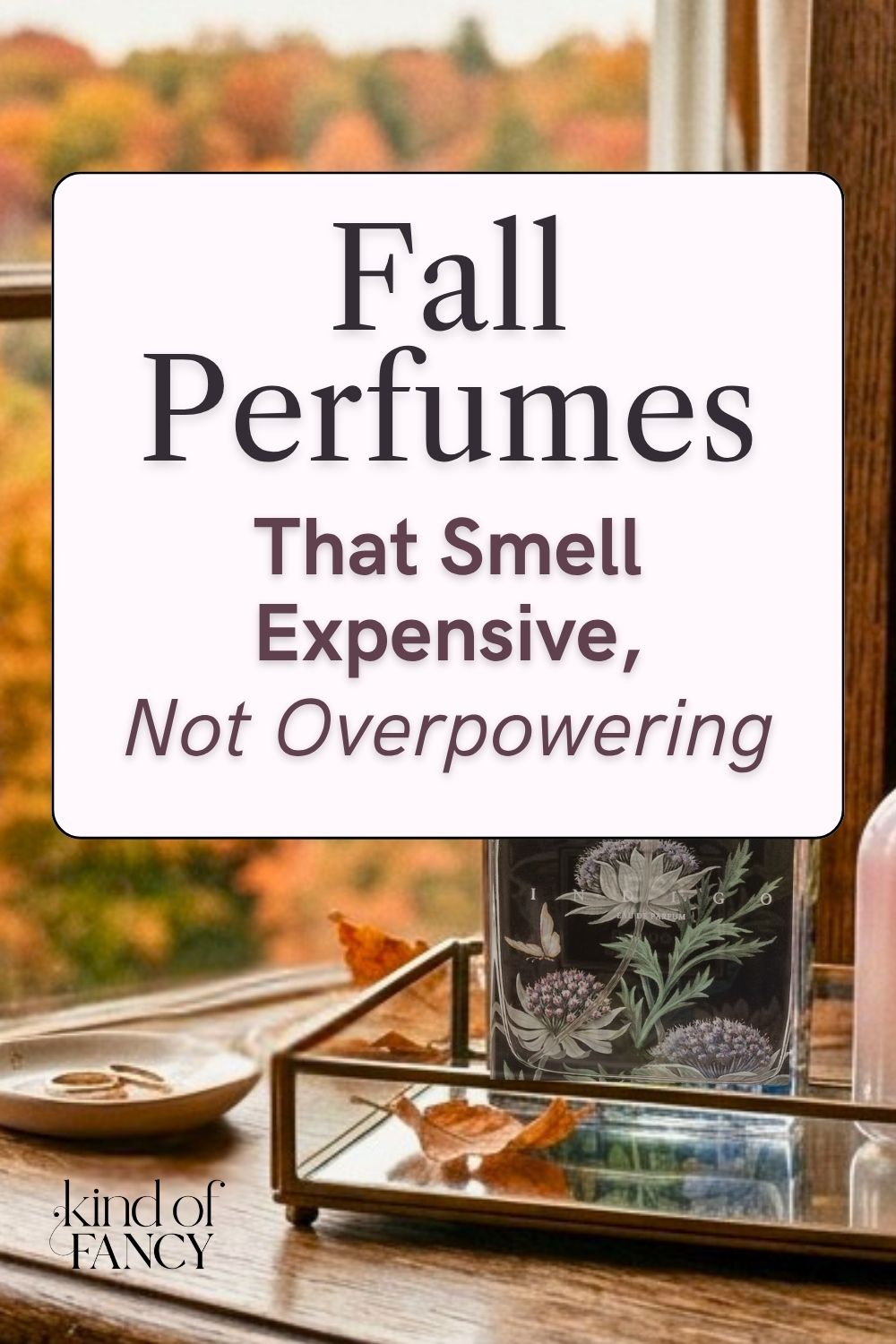 fall perfumes on an antique dresser against a bedroom window overlooking a autumn colored tree line.