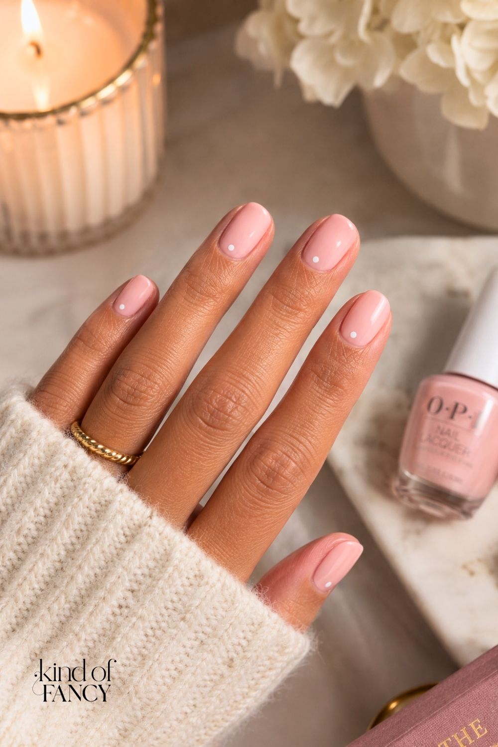 Pink and white manicure with a small white dot near each nail base